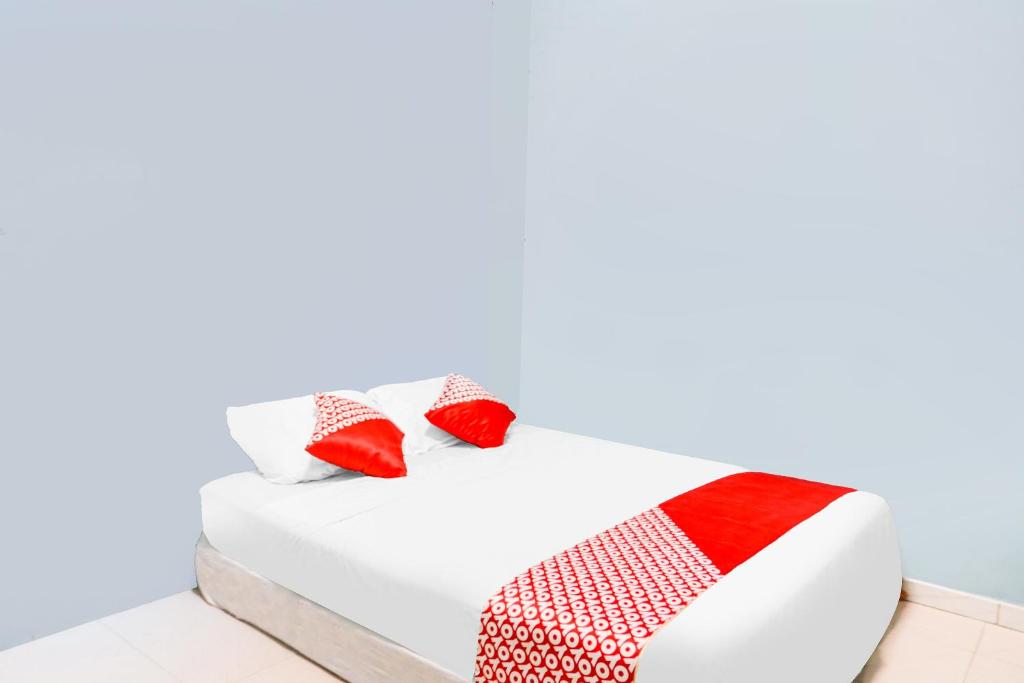 巴都安帕SPOT ON 92072 Restu Ibu Homestay Syariah的白色的床和红色和白色的枕头