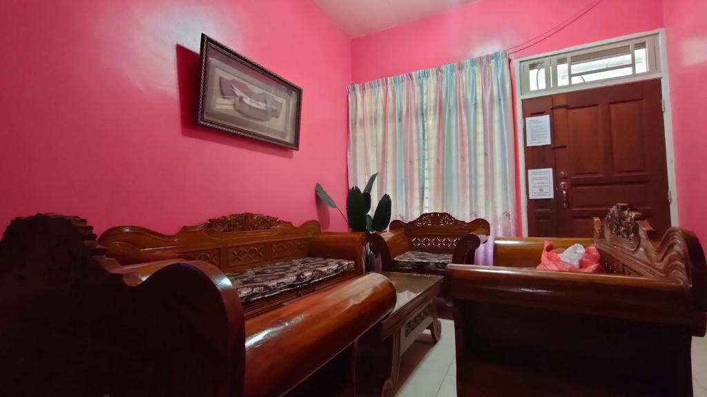 乌鲁地南Zulaikha's Homestay Ulu Tiram Johor Bahru的一间设有两张床和粉红色墙壁的客房