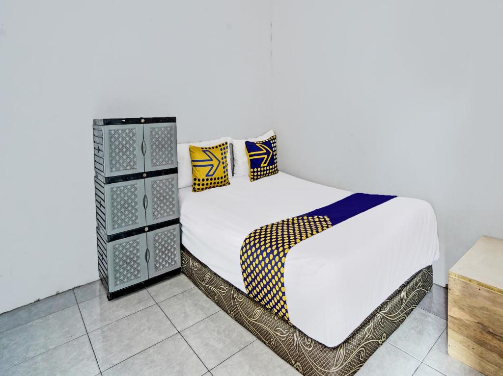 MojokertoOYO 92086 Fun Guesthouse Syariah的一张带白色床单和枕头的床