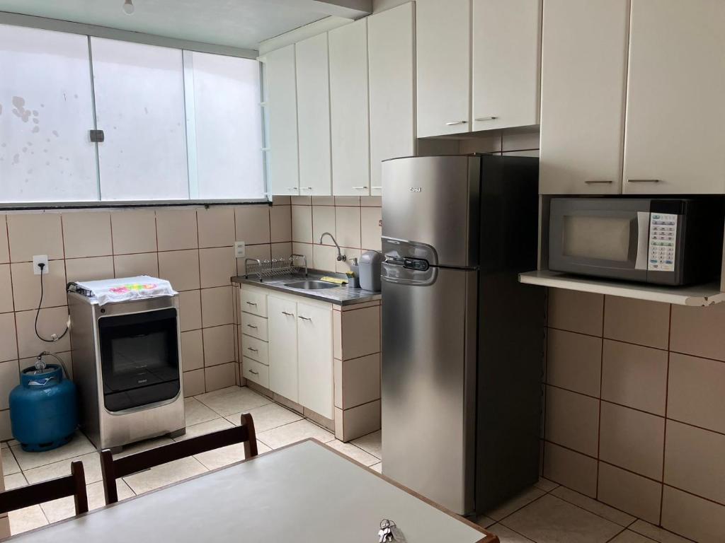 戈亚尼亚Apartamento 2 quartos Setor Sul的厨房配有不锈钢冰箱和微波炉。