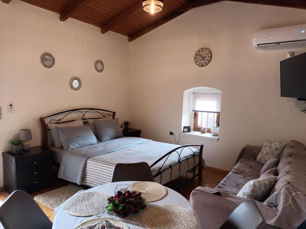 莫奈姆瓦夏Panagiotas House的一间卧室配有一张床和一张沙发