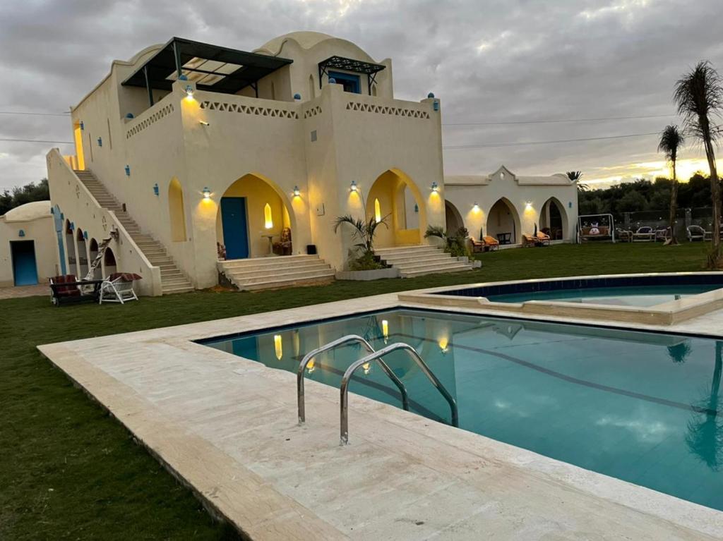 Qaryat at Ta‘mīr as SiyāḩīyahLake House by Tunisia Green Resort的房屋前有游泳池的房子