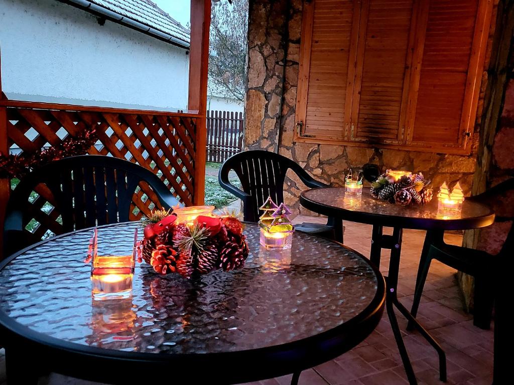 SarudWatAir House Apartman Sarud的两张桌子,上面有蜡烛,放在庭院