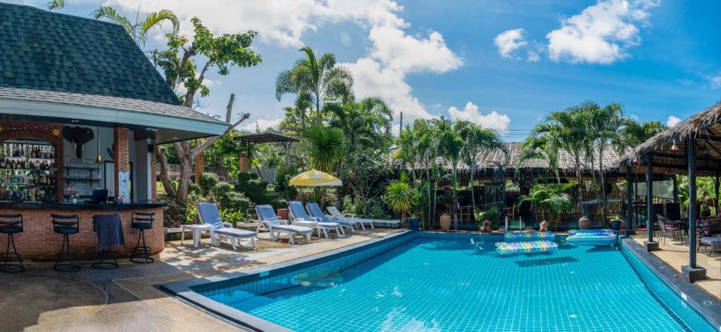 拉威海滩Harmony Naturist Resort Rawai Phuket 18yr minimum age only nudist nake d FKK的一个带椅子的游泳池以及一座房子