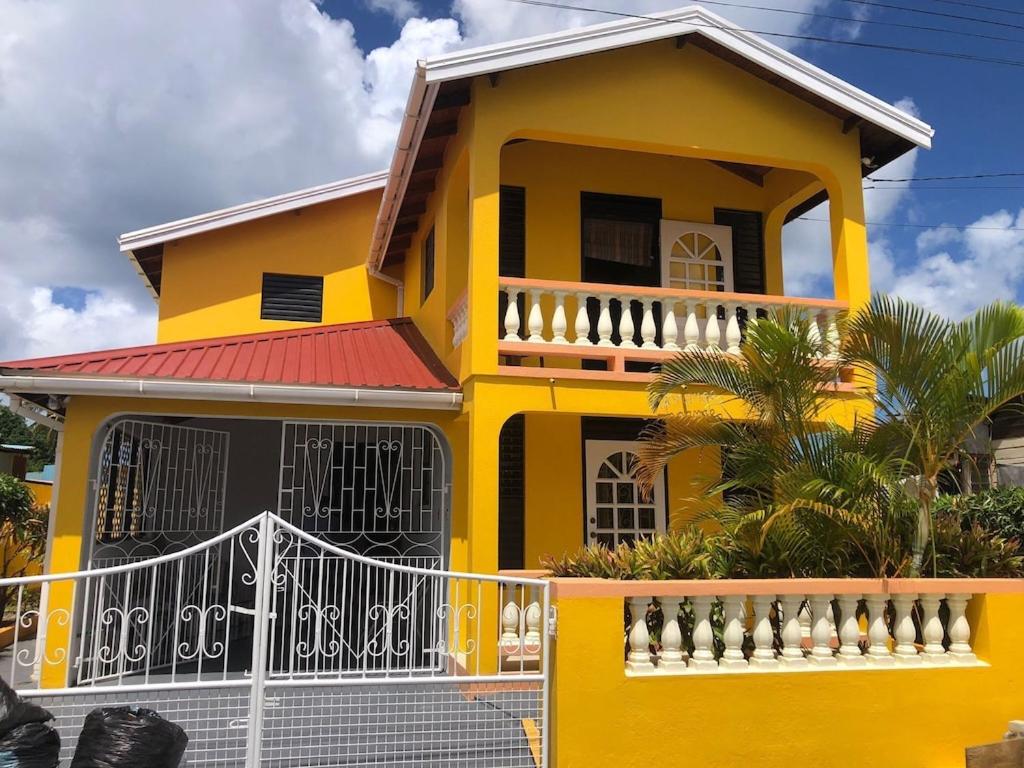 布里奇敦DonaMae 2 story Barbados House的前面有白色围栏的黄色房子