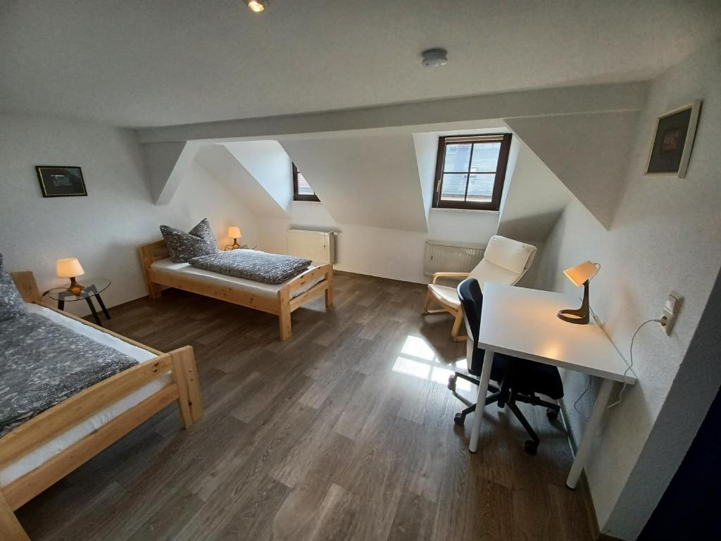 茨维考L118 Vermietungen的阁楼间配有1张床、1张桌子和1张桌子
