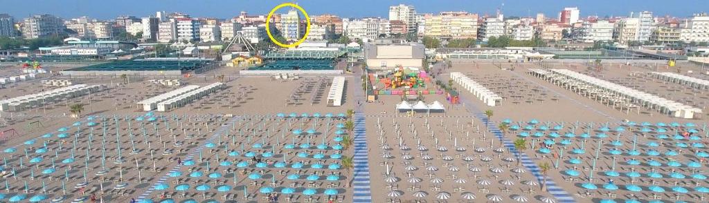 索托马里纳Hotel Ideal Sottomarina的享有海滩和城市美景,配有遮阳伞
