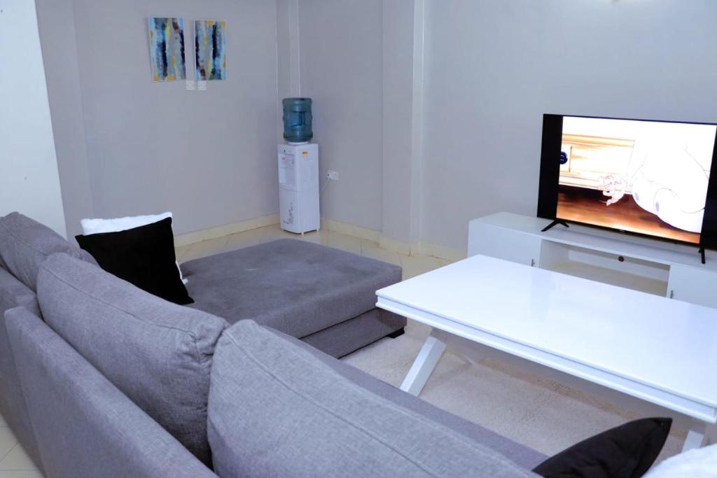 KisiiLovely 3 bedroom apartment, kisii的带沙发、桌子和电视的客厅