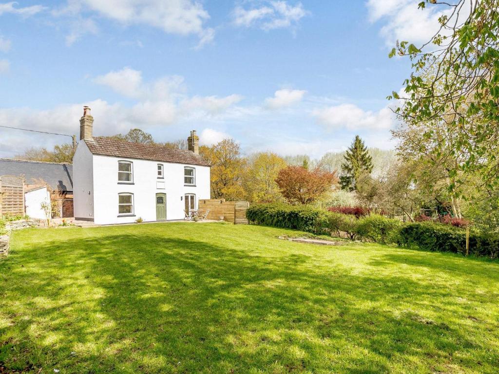 WoodfordSpinney Cottage的白色房子,有大草地庭院