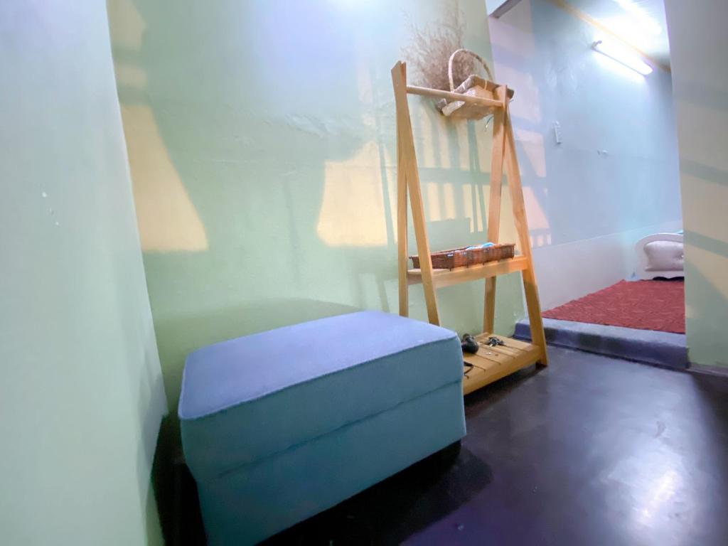 Kiến AnCúc cu Homestay 3的一间带椅子和蓝色搁脚凳的房间