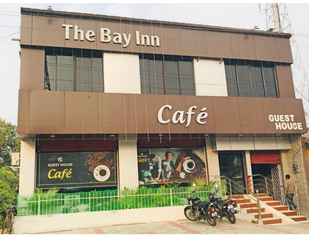 PānchagānHotel The Bay Inn, Konark的停泊在咖啡馆外的带摩托车的建筑