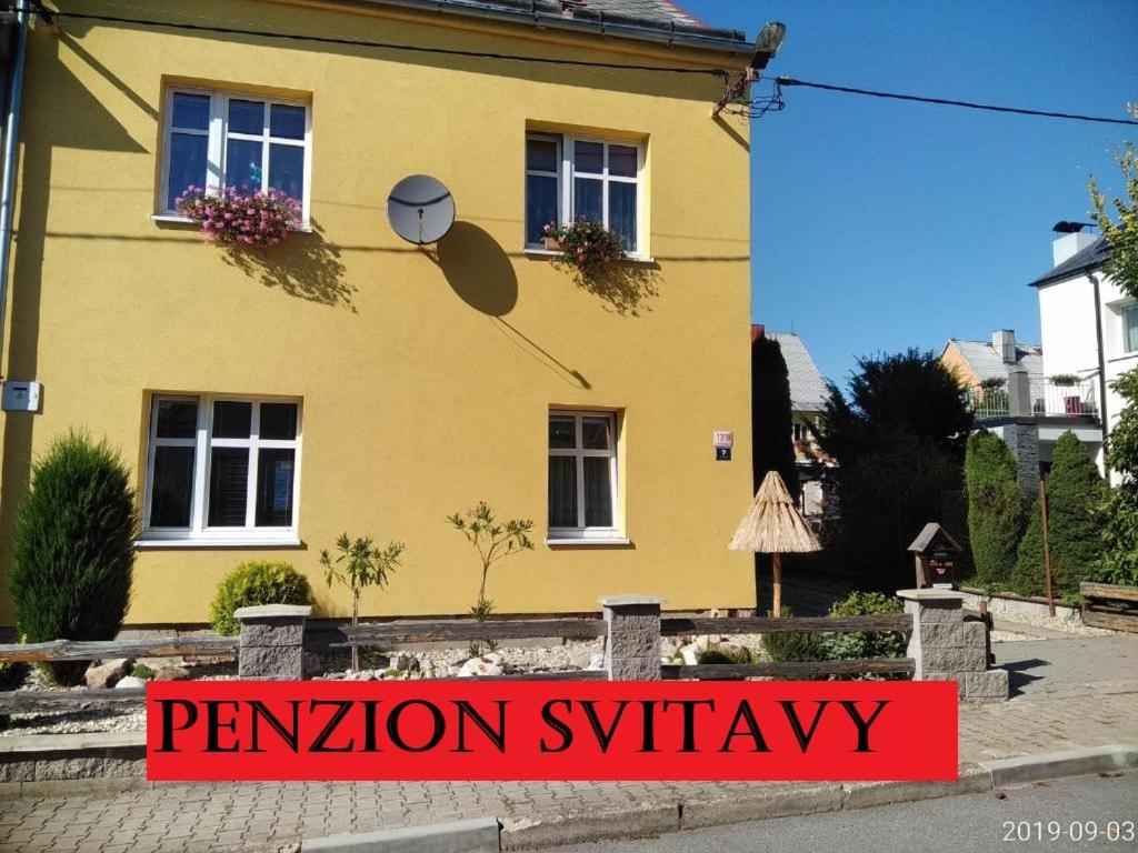 斯维塔维Penzion Svitavy的黄色房子前面有标志