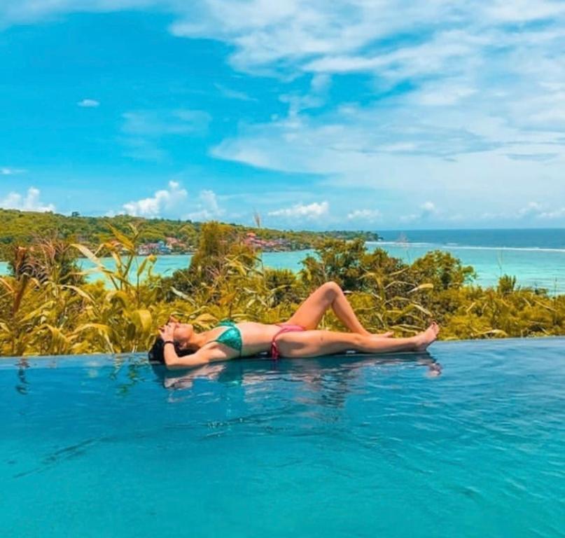 蓝梦岛Ocean Paradise Cottage的躺在游泳池里的女人