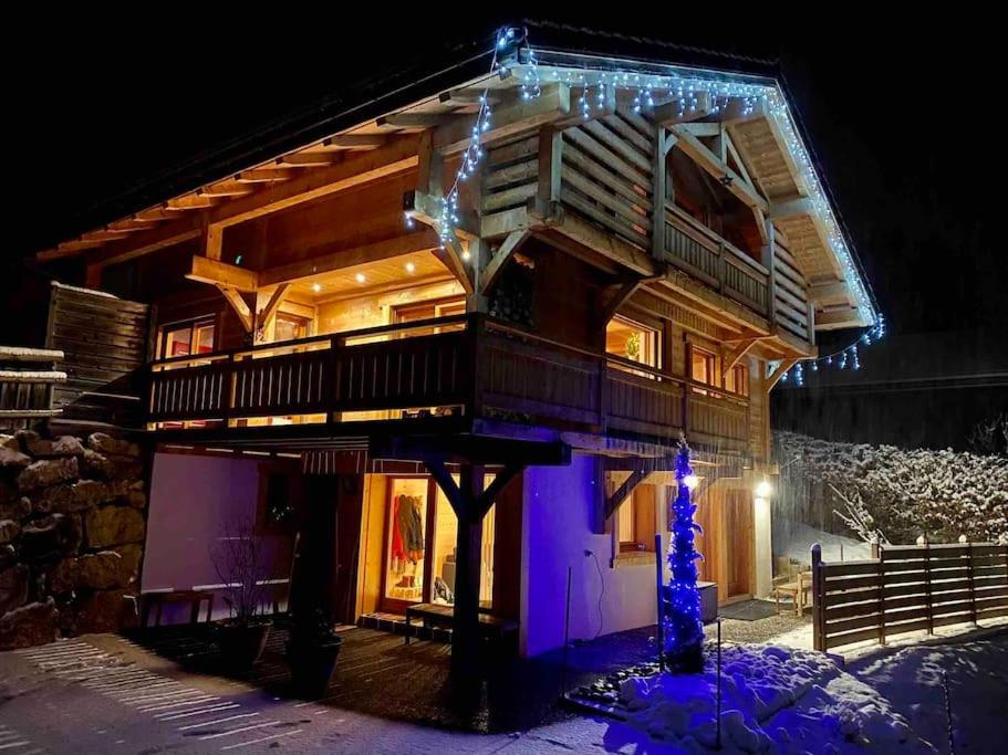 Les Villards-sur-ThônesAndrosace Appartement dans Chalet bois avec Jacuzzi privatif Terrasse et Vue Montagne的小木屋,上面有圣诞灯