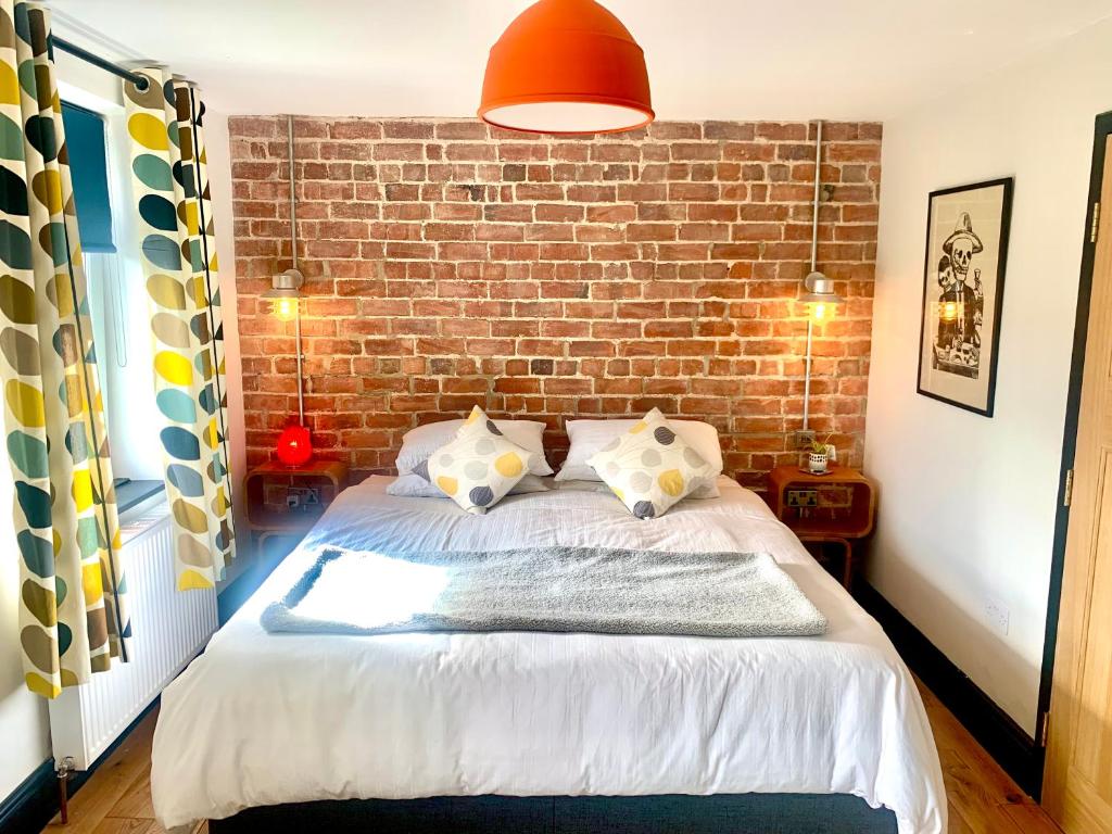 霍普Station Masters Cottage的一间卧室设有砖墙和一张床