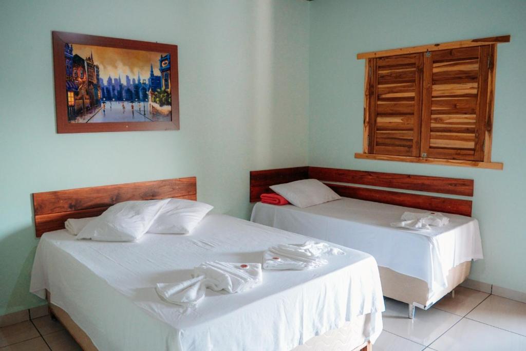 诺布里斯Pousada do Nondas的一间卧室设有两张床和窗户。