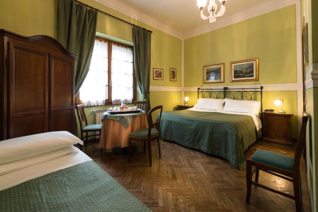 佛罗伦萨古老佛罗伦萨食宿客栈的酒店客房设有两张床和一张桌子。