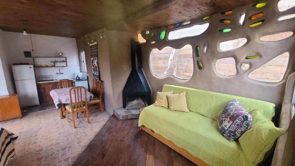 萨利纳斯Casita entre dunas al son del mar的一间带绿色沙发的客厅和一间厨房