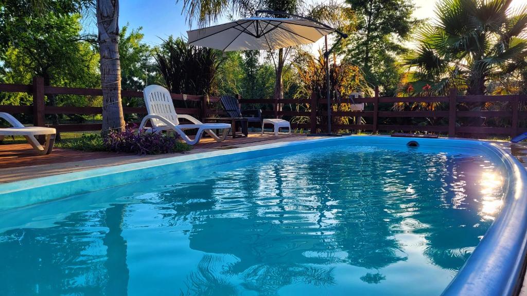 科隆Cabañas Pulmahue的一个带椅子和遮阳伞的游泳池
