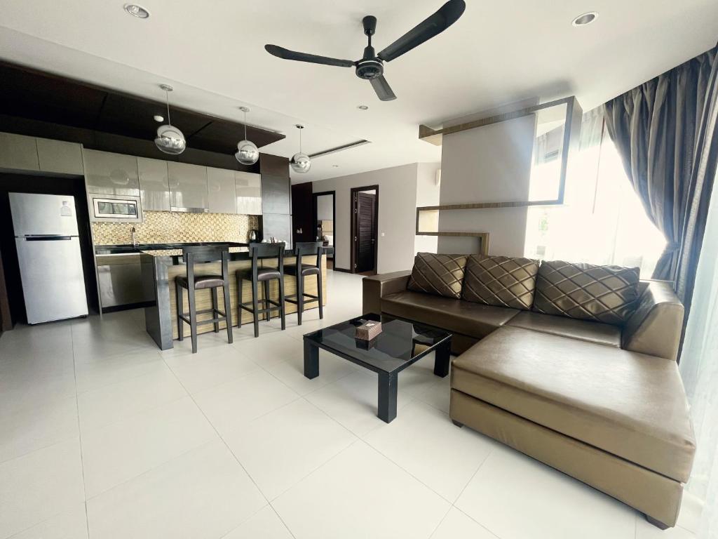 邦涛海滩The Regent Bangtao Apartments的客厅以及带沙发和桌子的厨房。