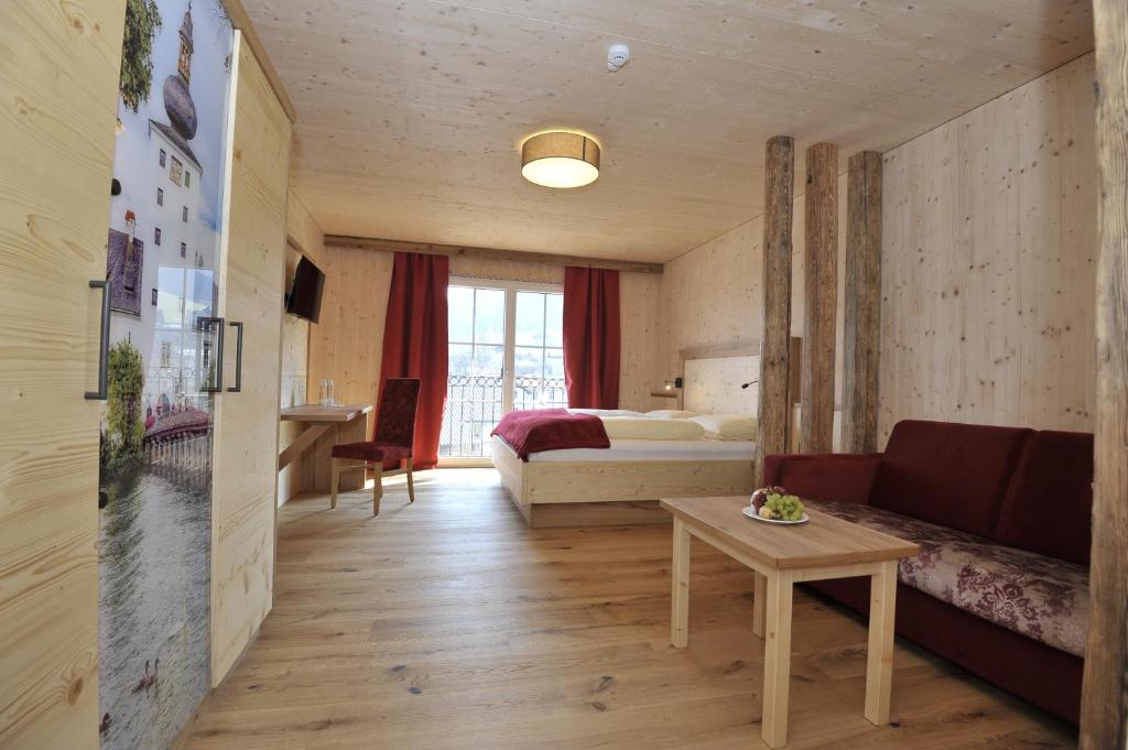 PinsdorfGasthaus Reiter的酒店客房配有床、沙发和桌子。