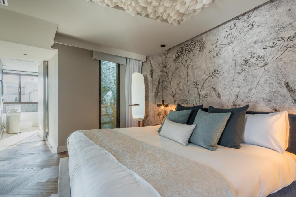 马德里Madrid 1915 Private Suites的卧室配有带蓝色枕头的大型白色床