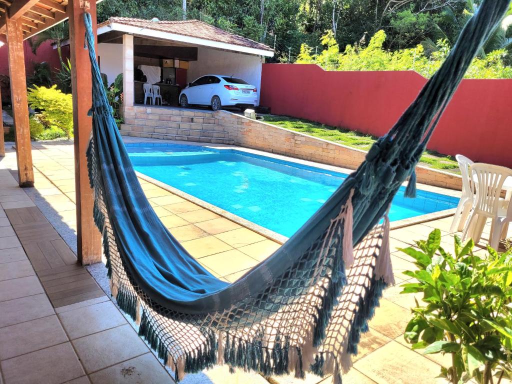 桑塔克鲁茨卡巴利亚Casa de praia / piscina的游泳池旁天井上的吊床