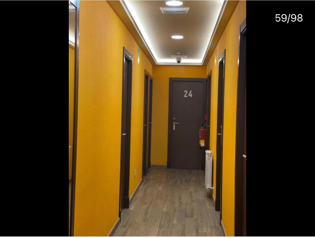马德里corazón San Bartolomé的走廊上设有黄色的墙壁,走廊上设有门