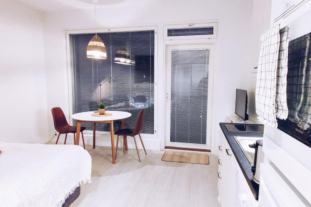 万塔New Studio Ruby near Helsinki Airport in Kivistö的白色的客房配有桌椅和窗户。