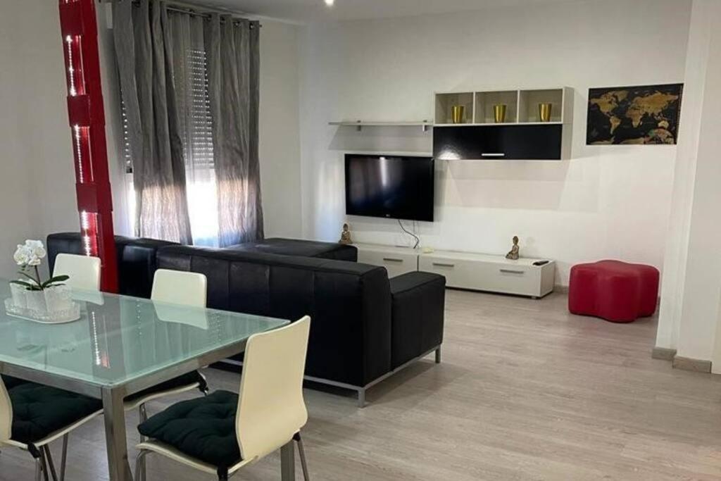 克雷维连特Lujoso y amplio apartamento en Crevillente的客厅配有黑色沙发和桌子