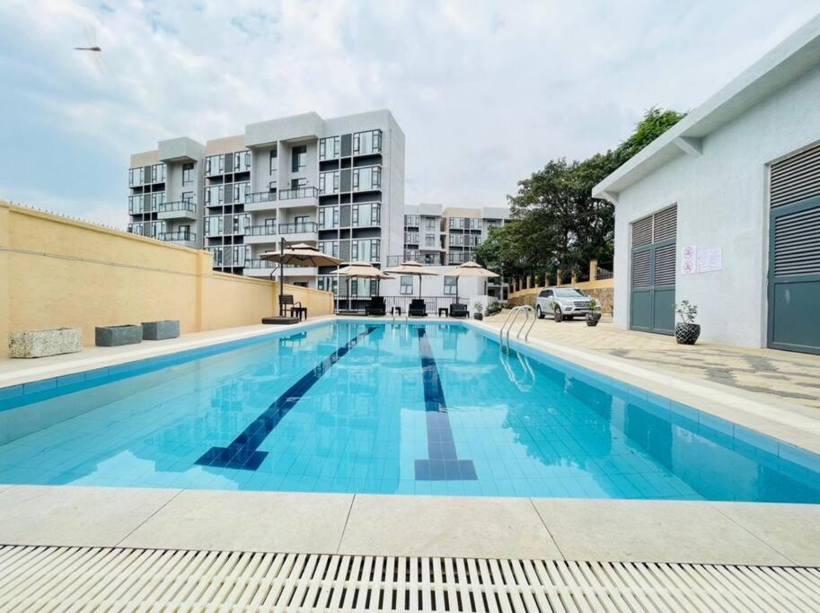 基加利Embassy Access Golf Apartment的大楼前的大型游泳池