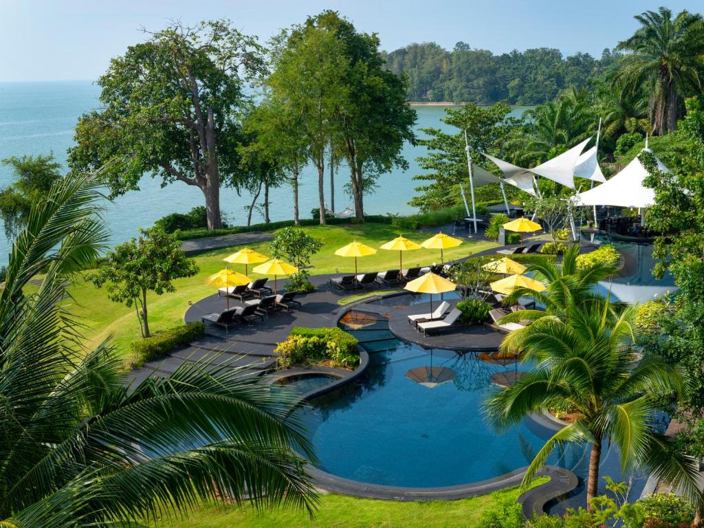班奥南矛The ShellSea Krabi I Luxury Beach Front Resort & Pool Villa的享有带遮阳伞的度假村游泳池的空中景致