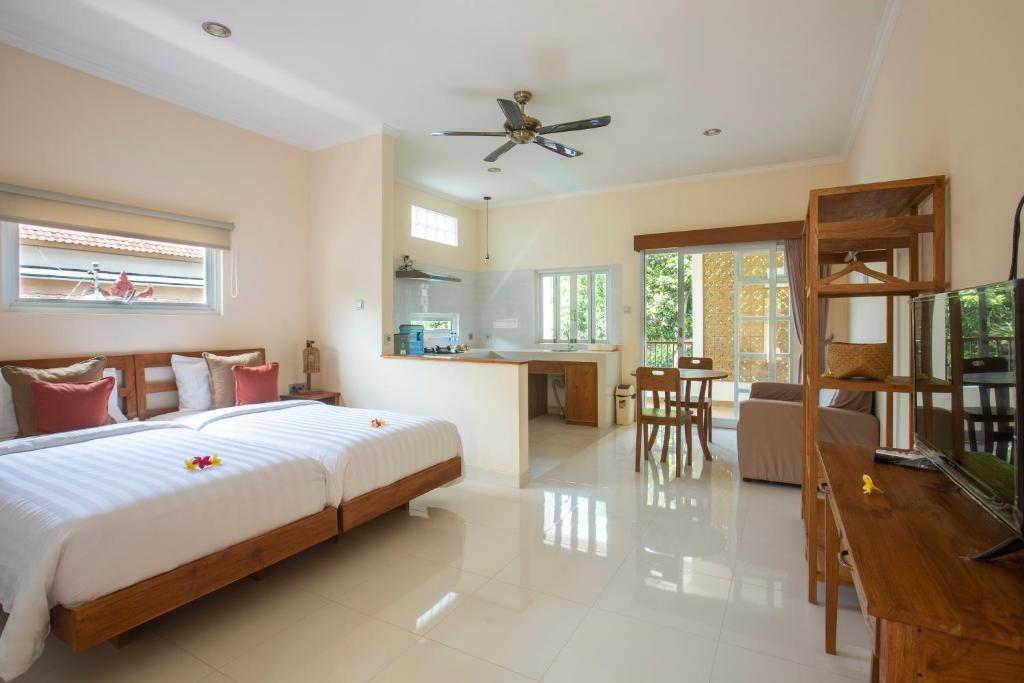 金巴兰Donguri House Bali的一间卧室设有一张床、一间客厅和一间厨房