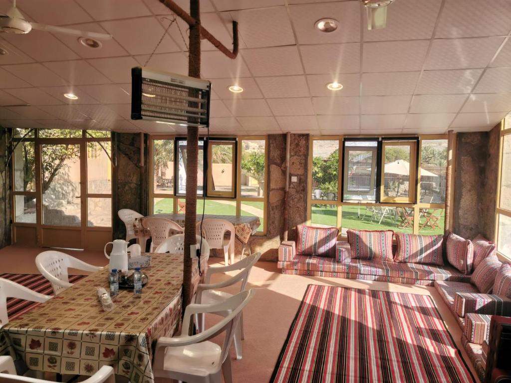阿尔哈姆拉The Wadi Inn的餐厅配有桌椅和沙发