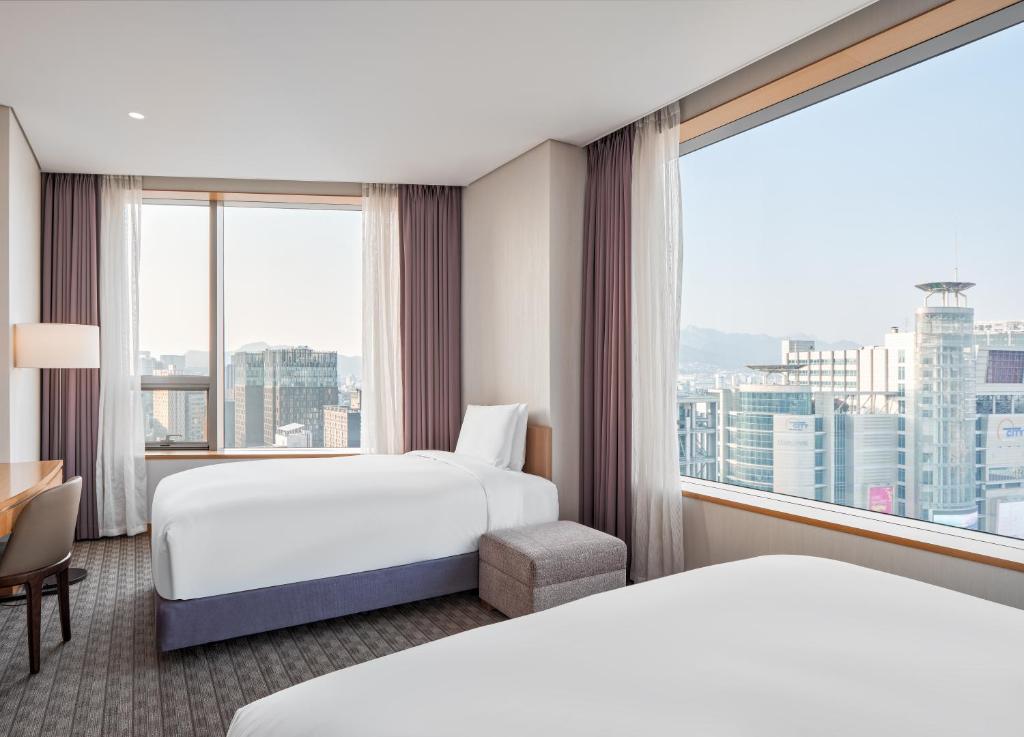 首尔喜普乐吉酒店首尔东大门的酒店客房设有两张床和大窗户。