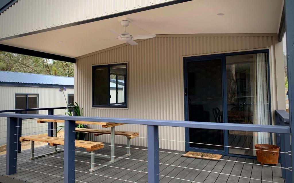 NicholsonLakes Bushland Caravan & Lifestyle Park的一个带桌子和长凳的屏蔽门廊