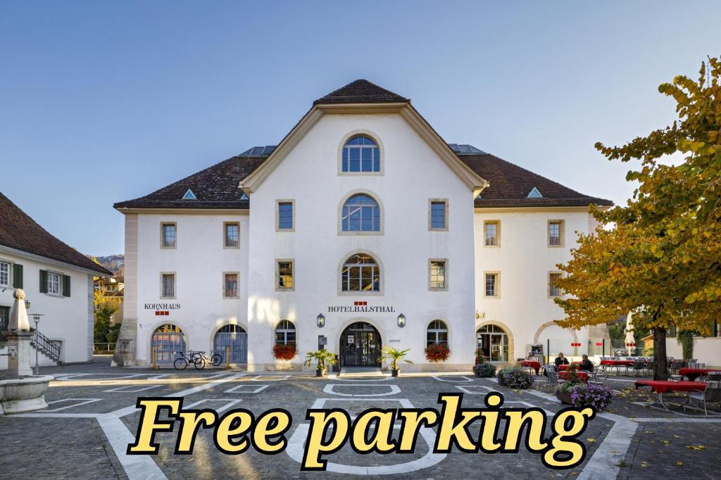 巴尔斯塔尔巴尔斯塔尔酒店的一座白色的大建筑,有字条免费停车场