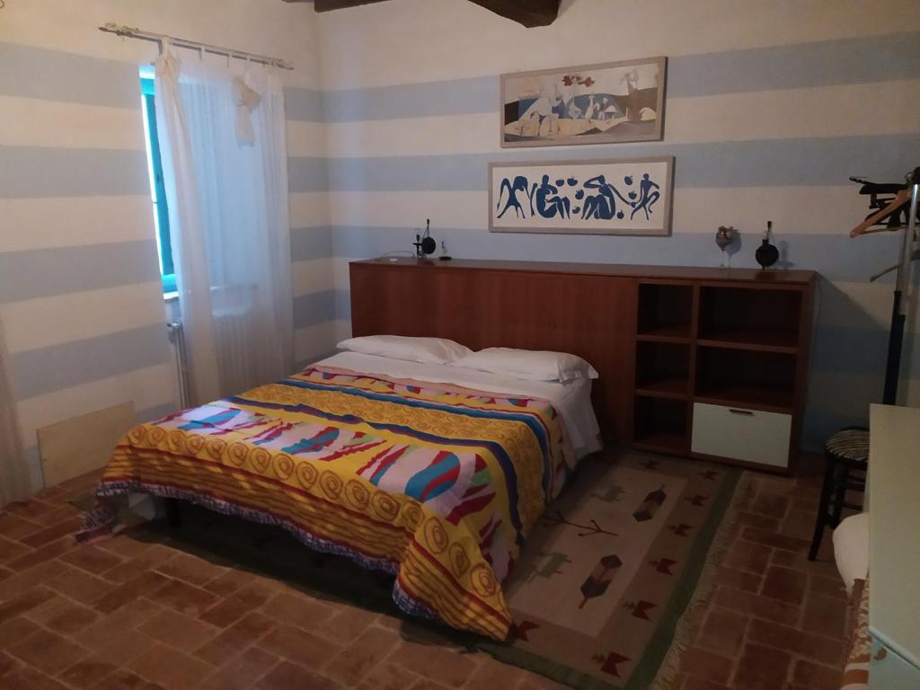 Villa CollemandinaAgriturismo Paneolio的一间卧室配有一张带条纹墙的床