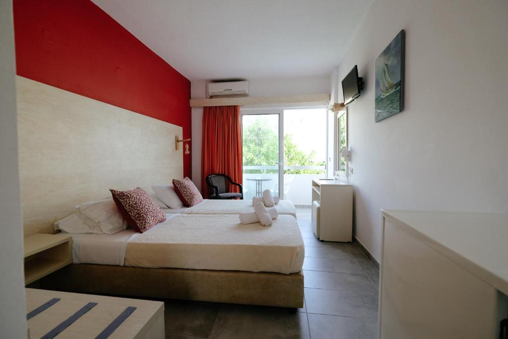罗德镇海伦娜酒店的一间卧室设有两张床和红色的墙壁