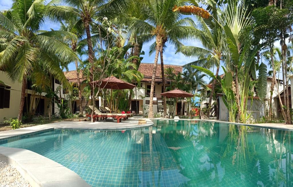 暹粒Natural Relax Villa的棕榈树屋前的游泳池