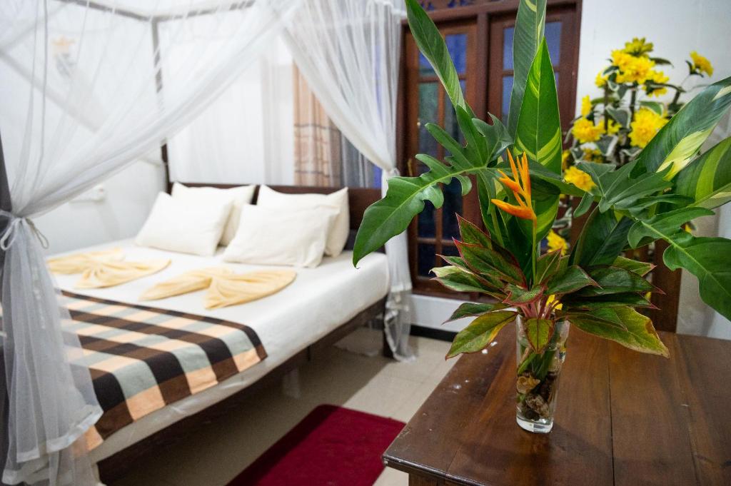 乌纳瓦图纳Villa Sunimal的一间卧室配有一张床和一张鲜花桌