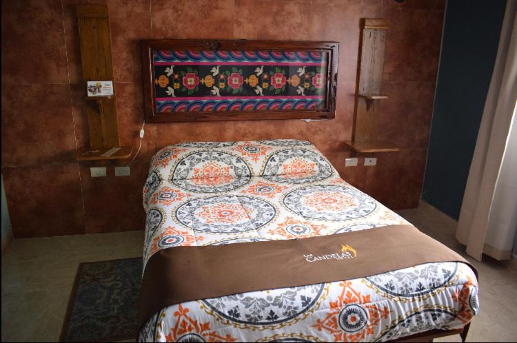 瓦曼特拉Hotel Las Candelas de Huamantla的一间卧室配有床,床上装有被子