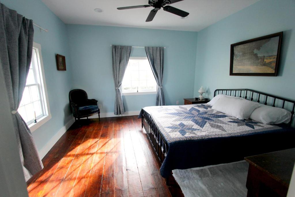 SmicksburgCozy, historic 5-bedroom home in Amish country的一间卧室配有一张床和吊扇