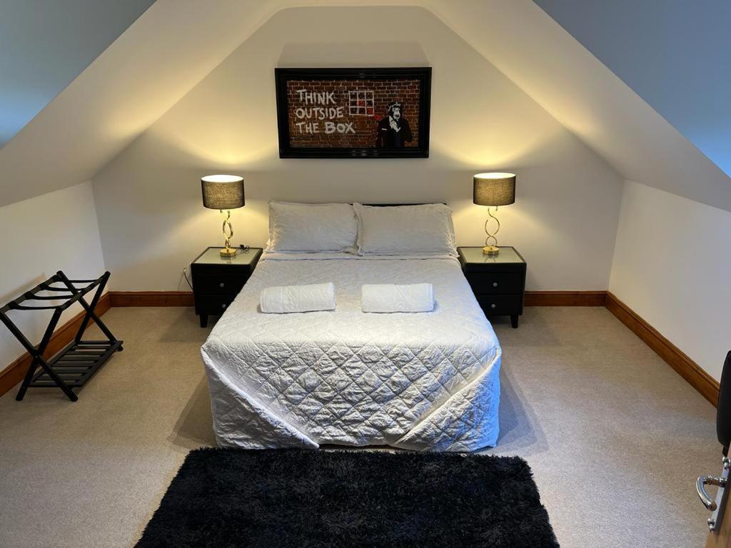 The Jagdamer Lodge的一间卧室配有一张带2个床头柜和2盏灯的床。
