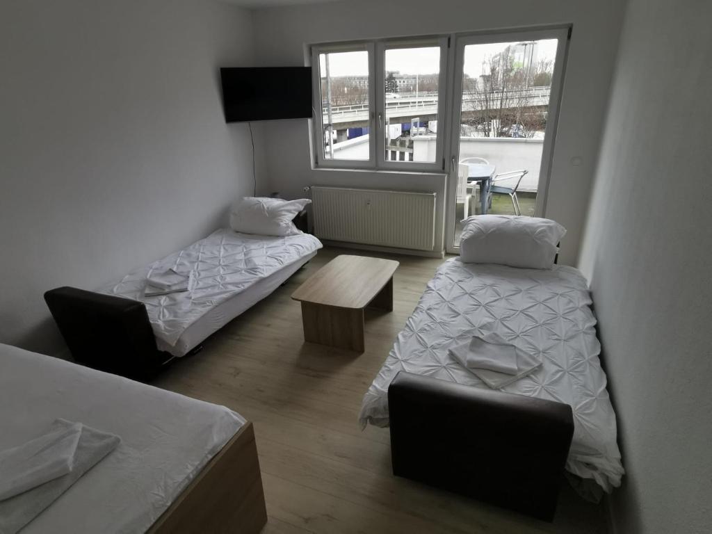 科隆Ferdimesse Apartments 2的客房设有两张床、一张桌子和一扇窗户。