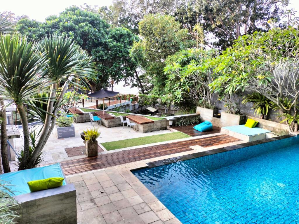 巴图卡拉JavaCove Beach Hotel的一座树木繁茂的庭院内的游泳池