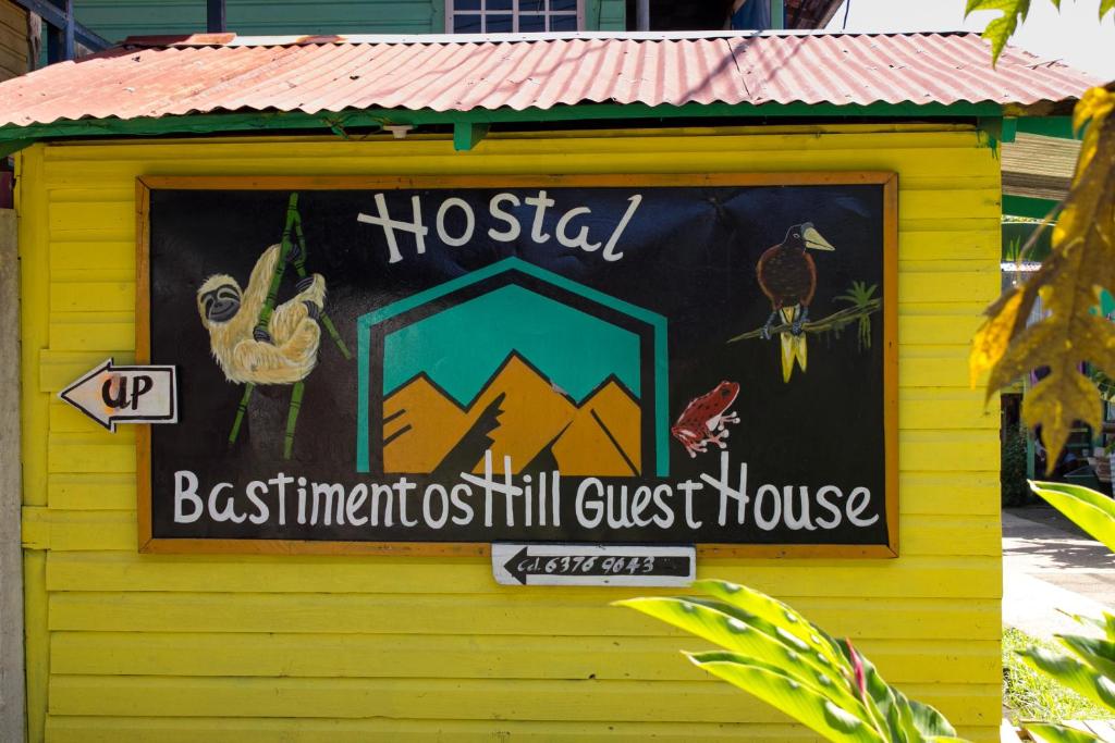 博卡斯德尔托罗Bastimentos Hill Guest House的黄色建筑中旅馆标志