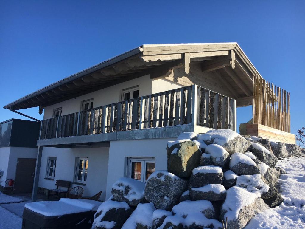 考夫博伊伦Allgäu-Chalet Kaufbeuren的一堆积雪上带阳台的房子