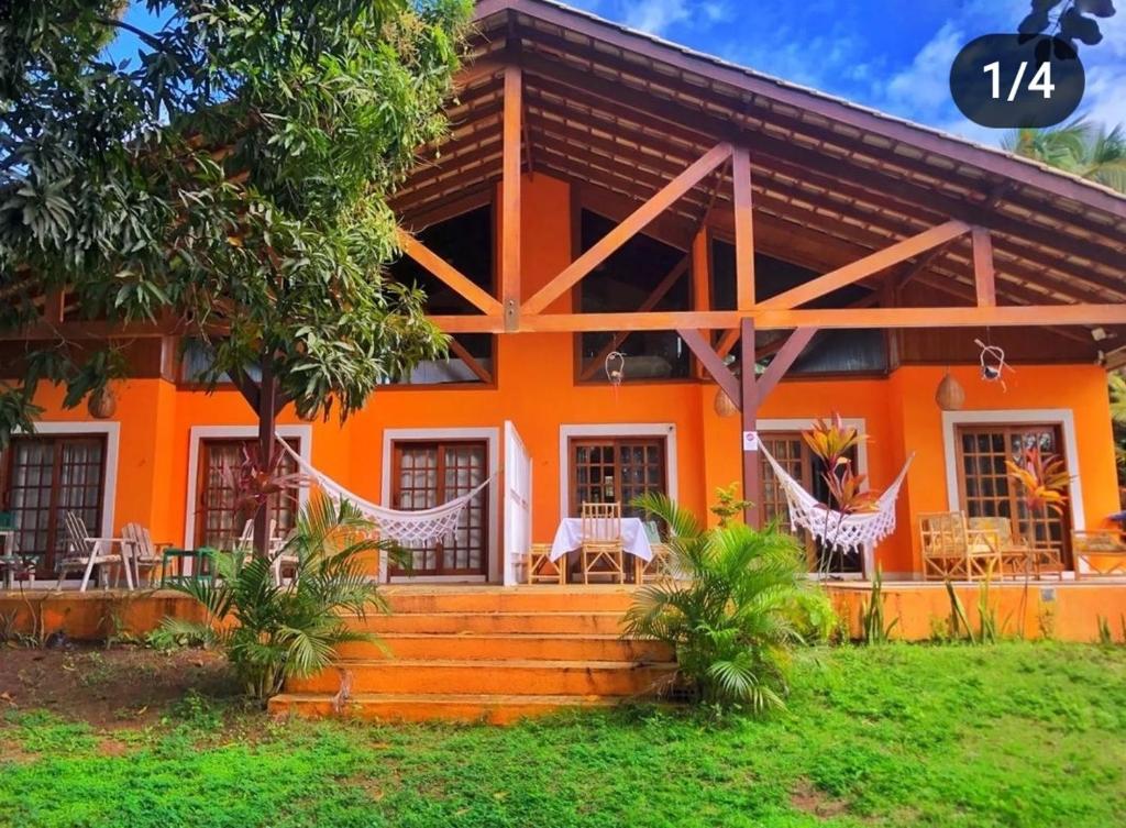 皮帕Paraíso Sítio da prainha的一座橙色房子前面摆放着椅子