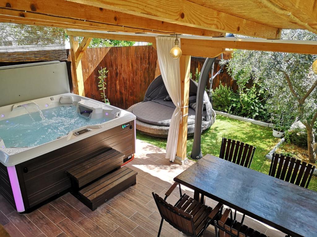 斯普利特Apartment Vespa & Jacuzzi的庭院内的热水浴池,配有桌子